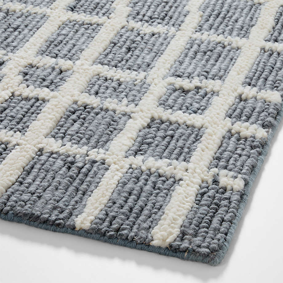 Handwoven Wool Area Rug close-up of a textured gray and white checkered rug on a light background