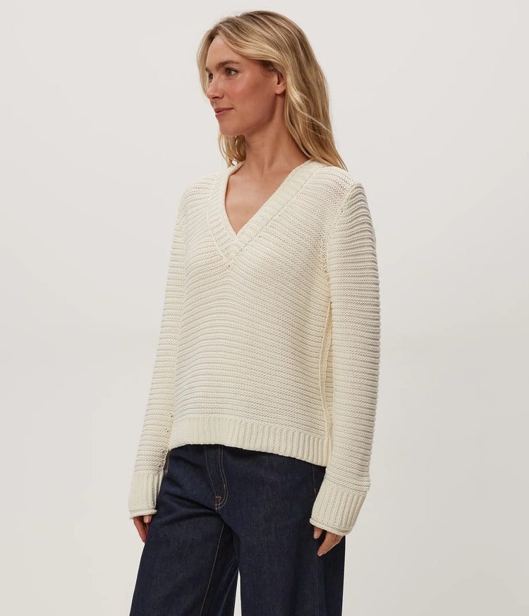 Coastal Ranch Sweaters-Cream-V-neck worn on model with dark navy jeans against white background 