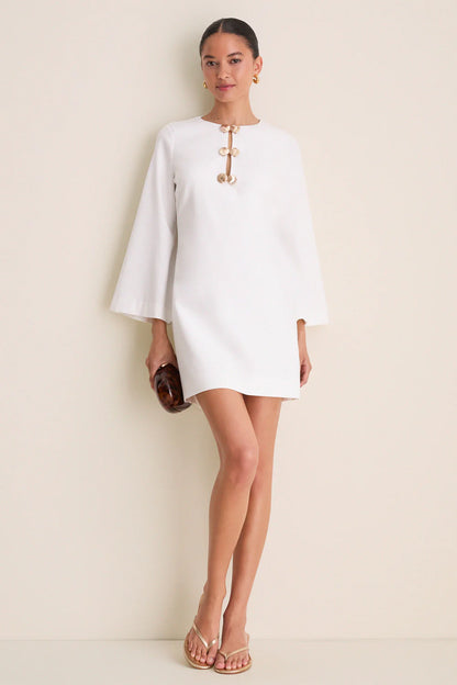 Ivory linen mini caftan — full length front view, model holding clutch, wide sleeves and mini length