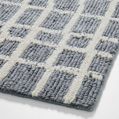 Handwoven Wool Area Rug close-up of a textured gray and white checkered rug on a light background