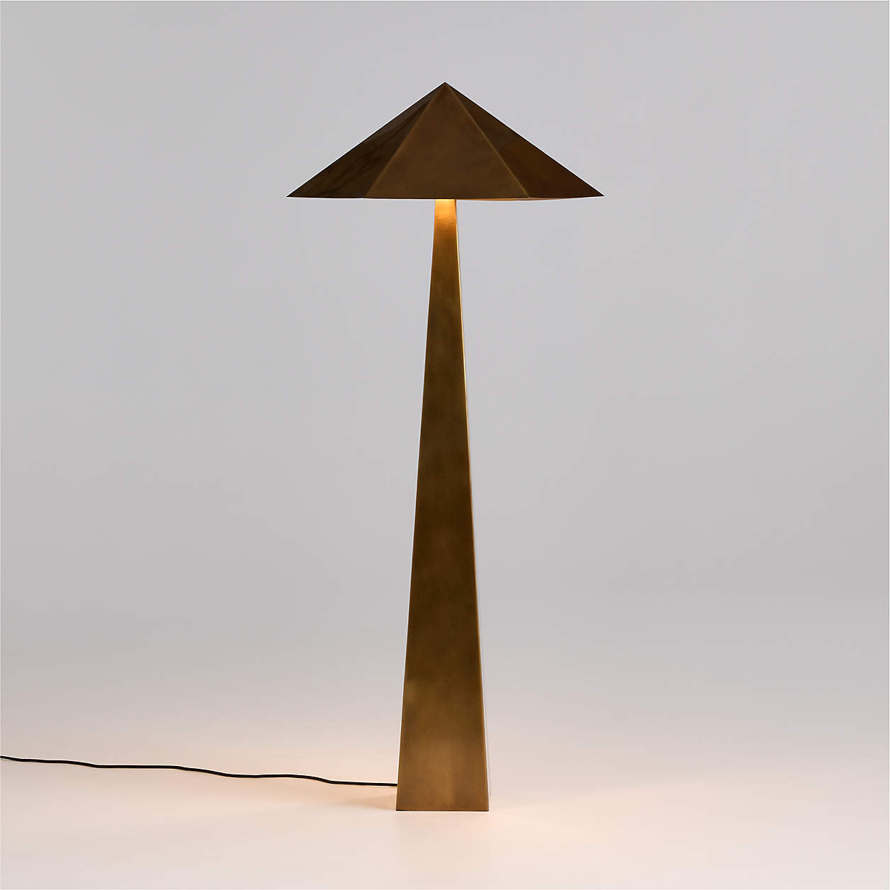 Modern brass geometric floor lamp with a geometric design on a light gray background
