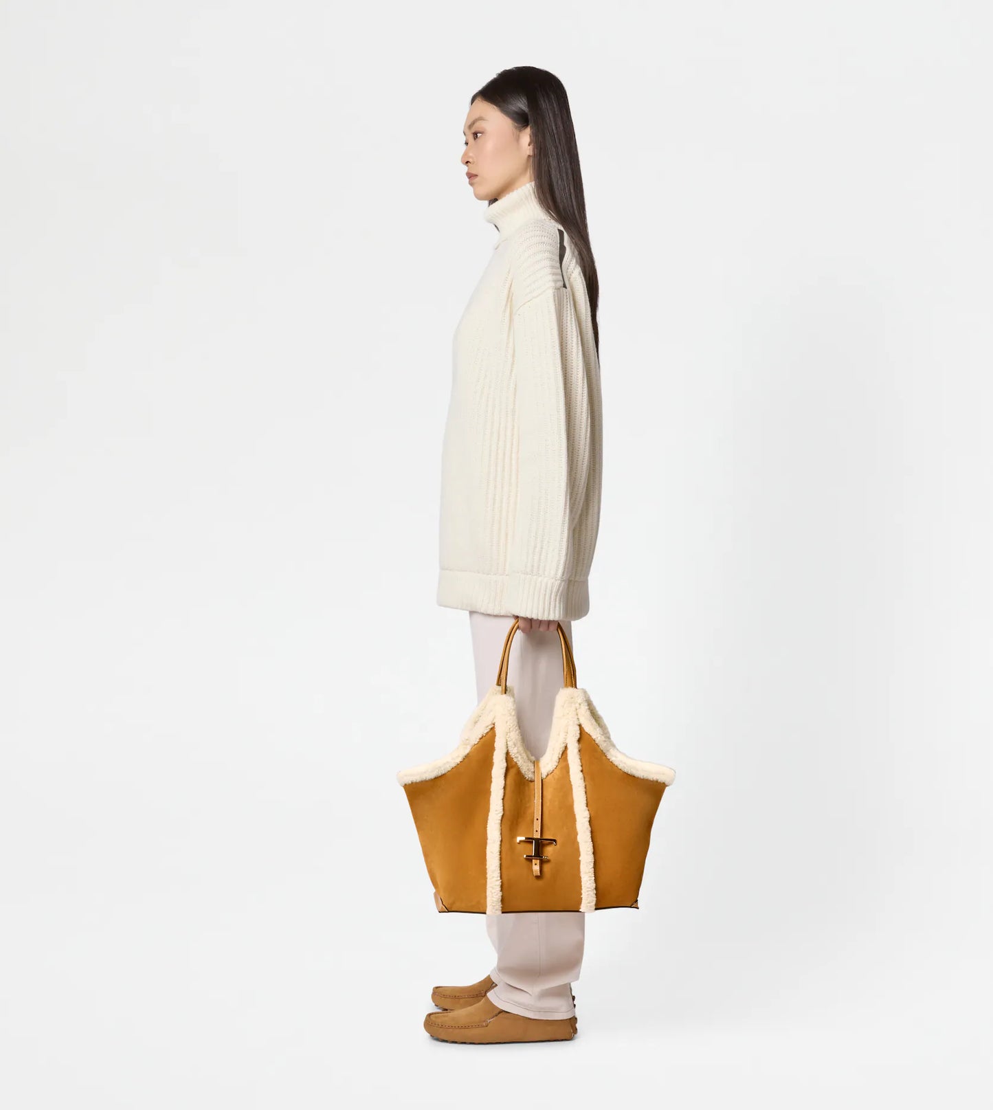 Medium suede shopping bag with soft sheepskin piping being held by women side view for scale-
