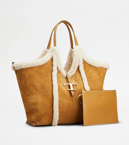 Medium suede shopping bag with soft sheepskin piping and metal T pendant in brown and white font view-