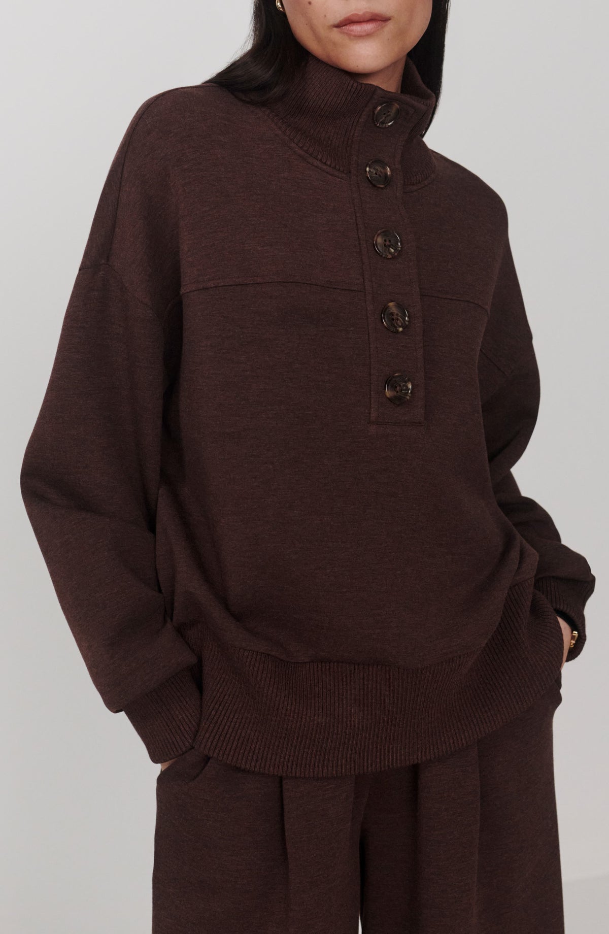 Brown button placket sweatshirt with tall rib collar and tortoise-look buttons, front view on model