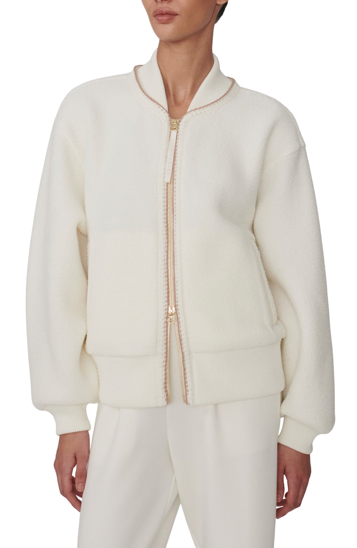 Cream fleece bomber jacket with tan contrast trim and gold-tone two-way zip, front view on model