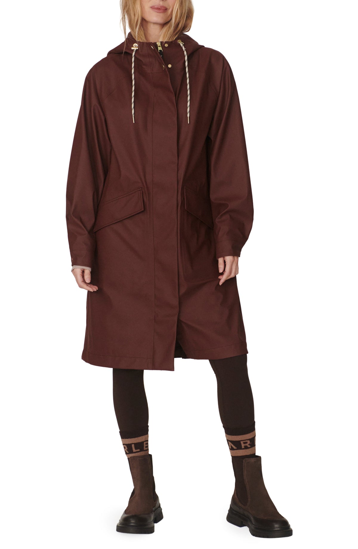Reddish brown long rain jacket with hood and cream drawcords, front view on model