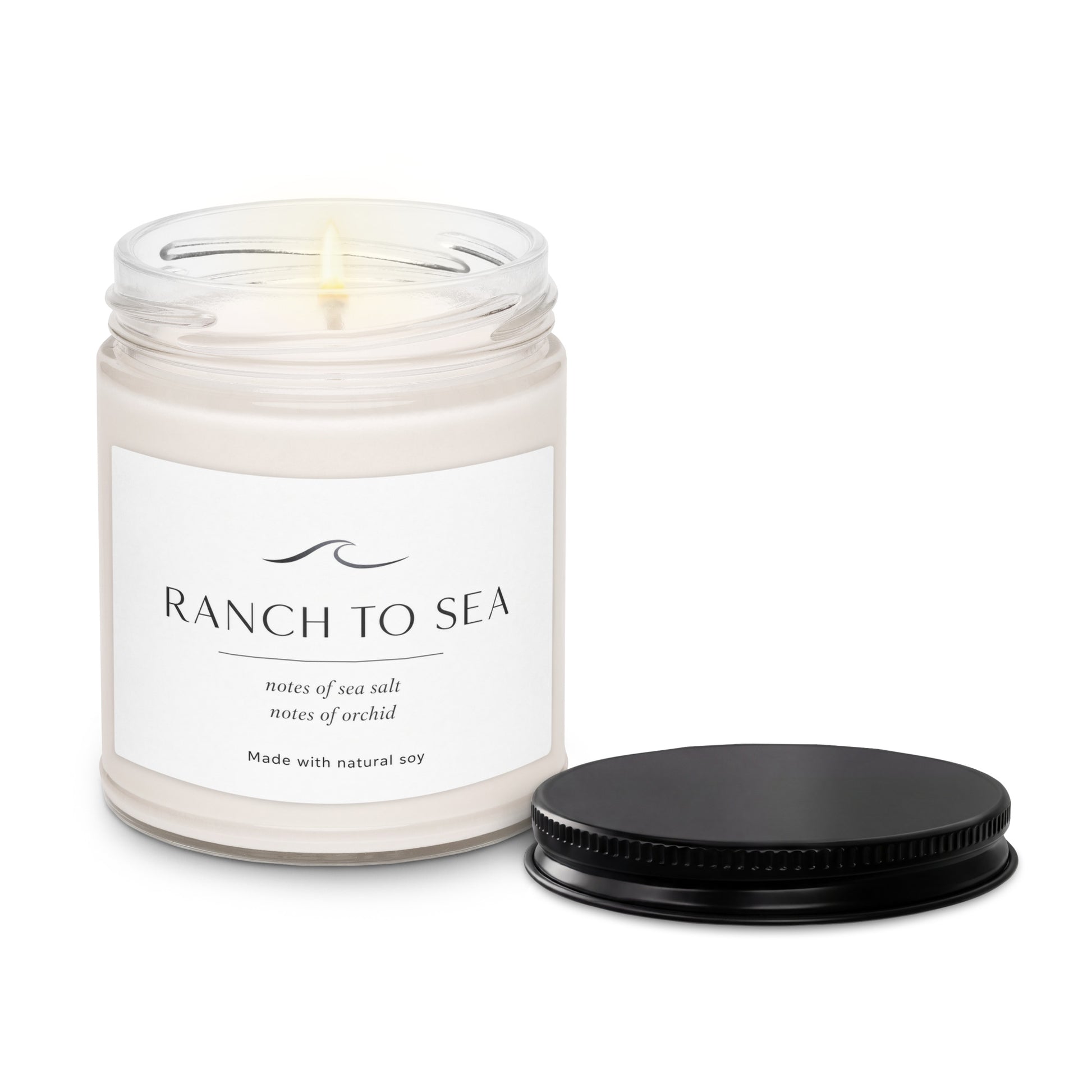 Product closeup with black lid off ter the fog natural soy candle in glass jar 